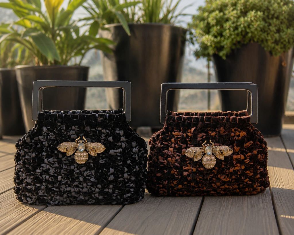 Cartera Velvet Lukkbags tejida a mano en terciopelo disponible en negro y chocolate con asa rectangular de madera y broche abeja dorado