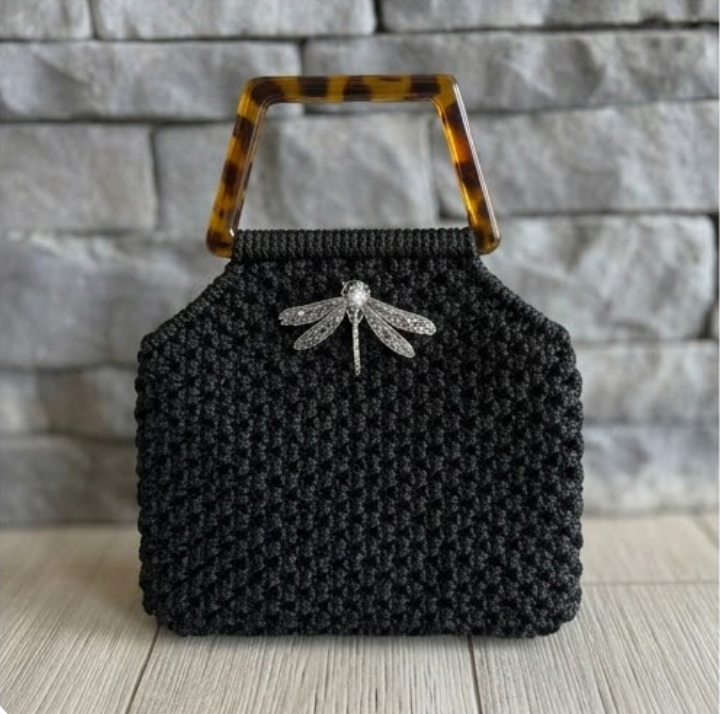 Cartera Zaya Lukkbags tejida a mano en macramé negro con asa cuadrada efecto carey y broche libélula plateado