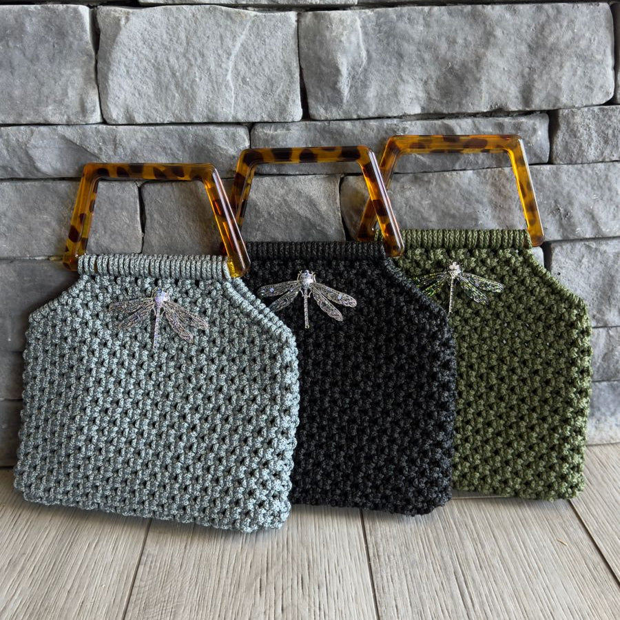 Cartera Zaya de Lukkbags tejida a mano en macramé disponible en gris, negro y verde oliva con asa cuadrada efecto carey y broche libélula plateado
